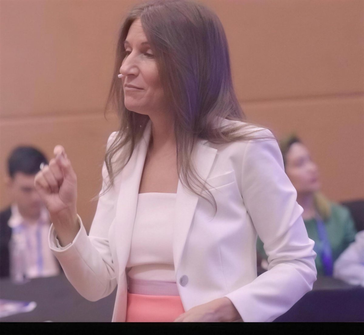 Korie Minkus leading a hands-on session in a white blazer